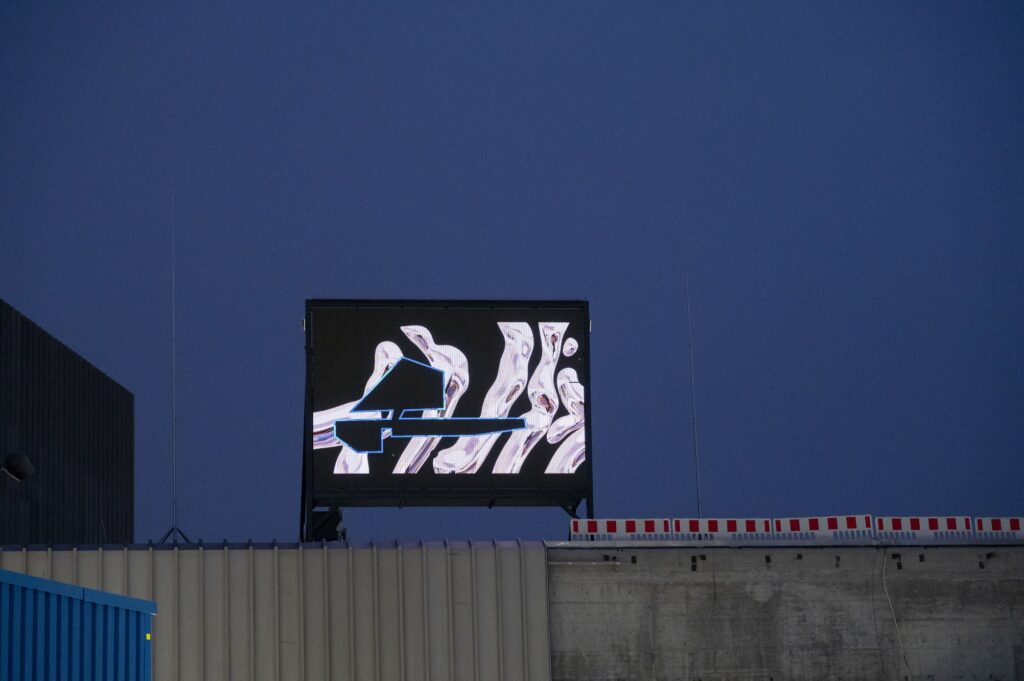 a screen standing on top of a building showing a pattern and theare outline